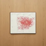 A minimalist top-down view of a wooden desk. On the desk, a beautifully structured paper planner is covered in chaotic, overlapping red ink scribbles and crossed-out time blocks, symbolizing a collapsed schedule. Soft, natural lighting, highly detailed, photorealistic.